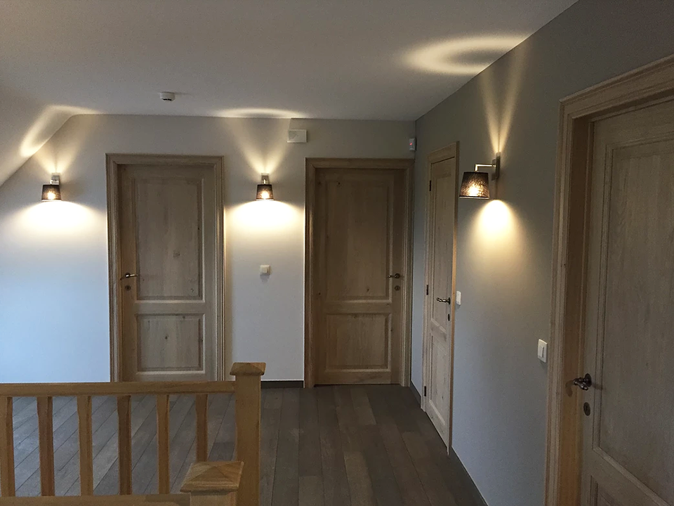 Sfeerbeeld van een gang met wandverlichting, een realisatie van Castelek.